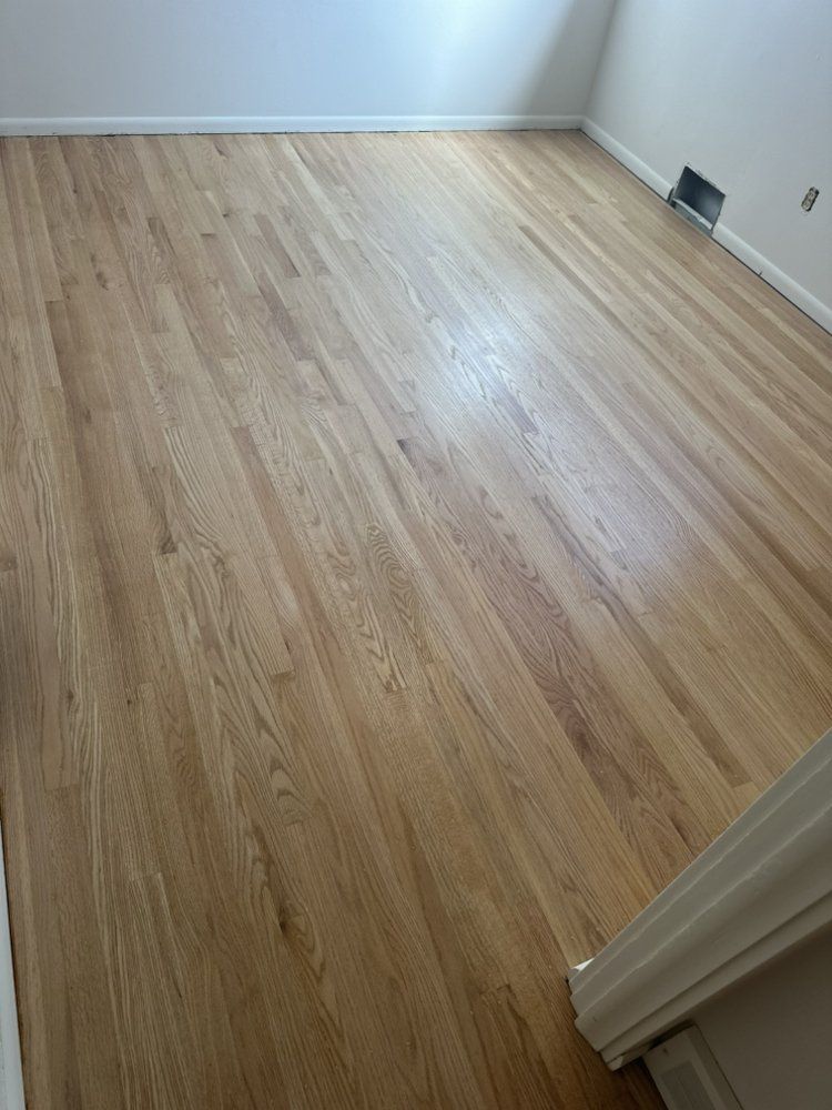 A room with a wooden floor and a white wall.