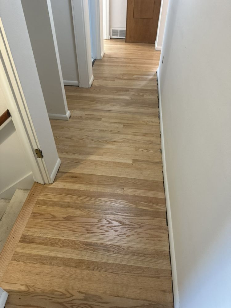 A hallway with hardwood floors and white walls
