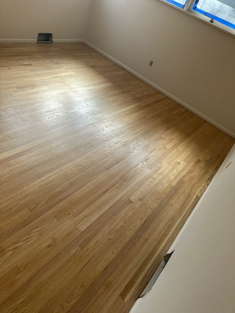 A room with a wooden floor and white walls.