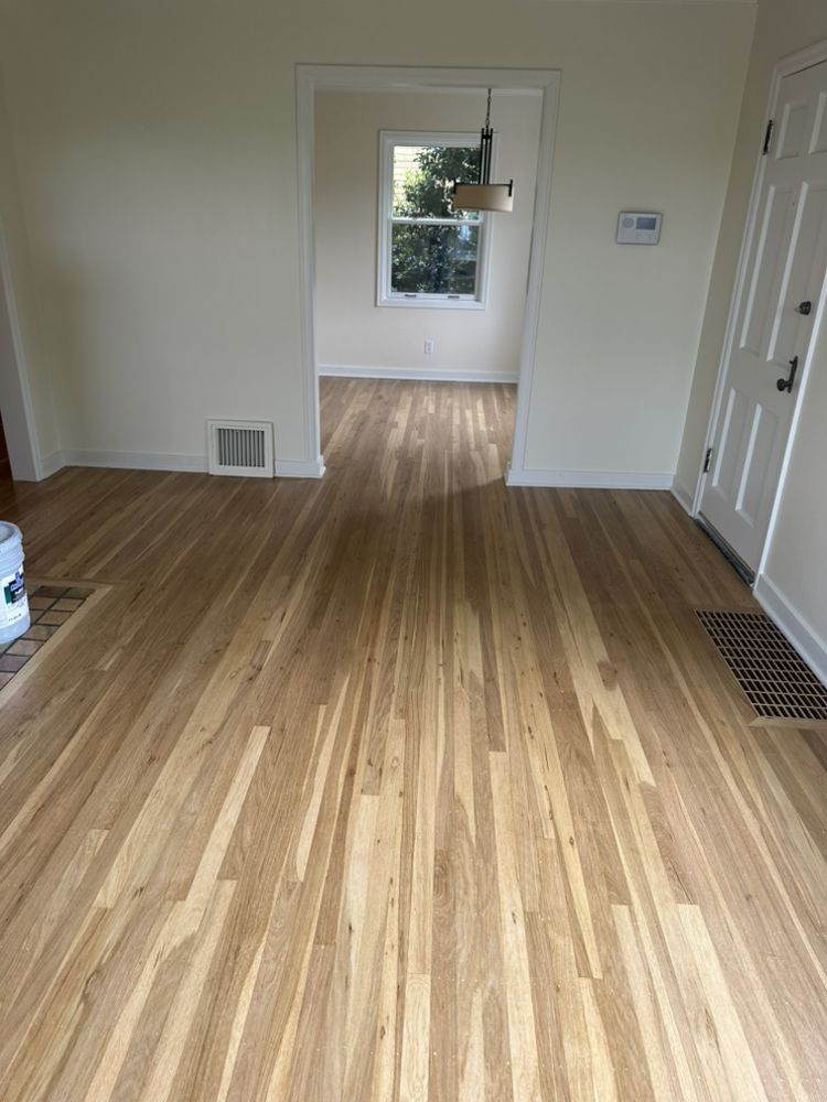 A living room with hardwood floors and white walls.