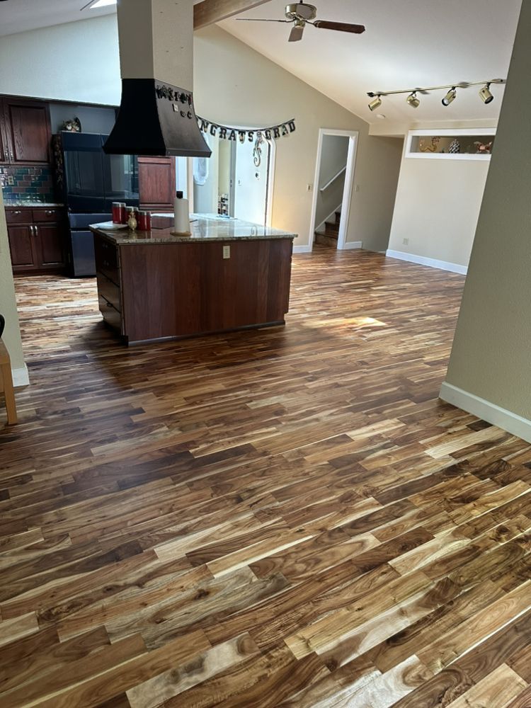 A kitchen with hardwood floors and a ceiling fan.