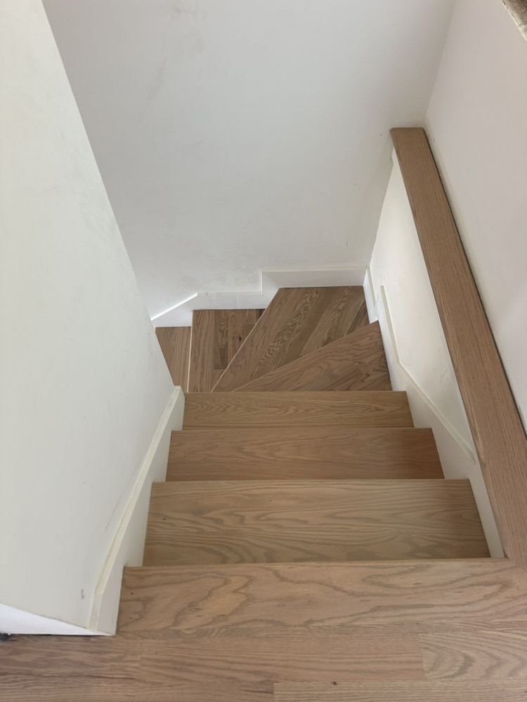 The stairs are made of wood and have a white railing.
