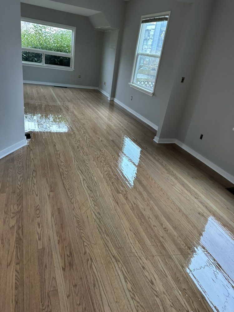 A living room with hardwood floors and a window.