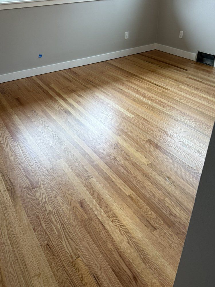 A living room with hardwood floors and a window.