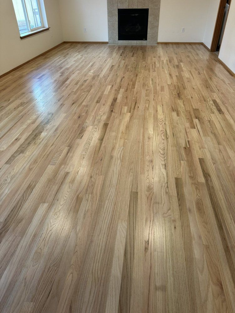 A living room with hardwood floors and a fireplace.