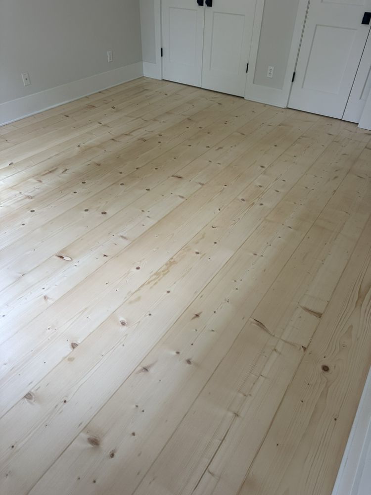 A room with a wooden floor and white doors.