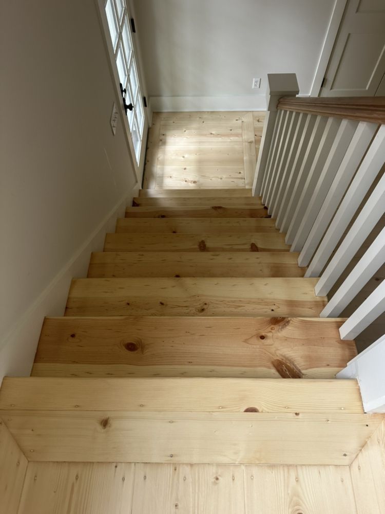 A wooden staircase with a white railing in a house.