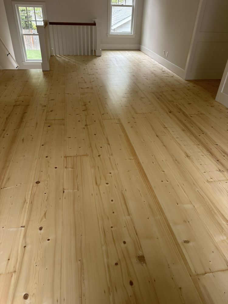 A living room with a wooden floor and stairs.