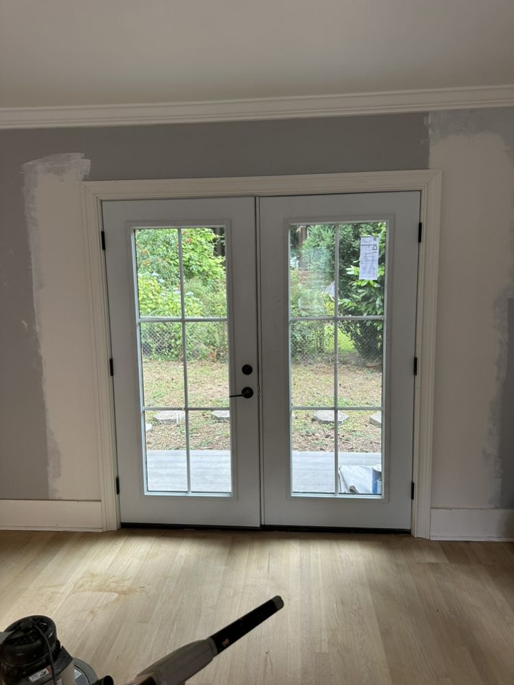 A room with a sliding glass door and a wooden floor.