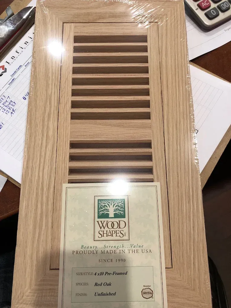 A wooden door is sitting on a table next to a calculator.