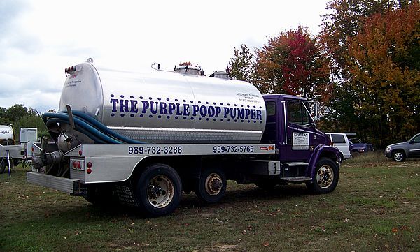 A purple septic truck with a silver tank labeled 