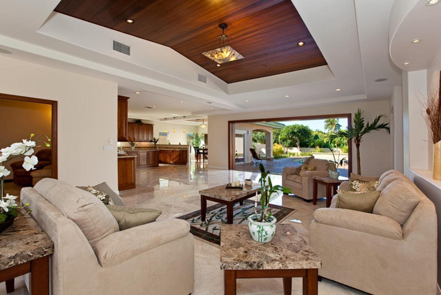 Luxurious living room with marble floors, couches, and a view to the outdoor area.