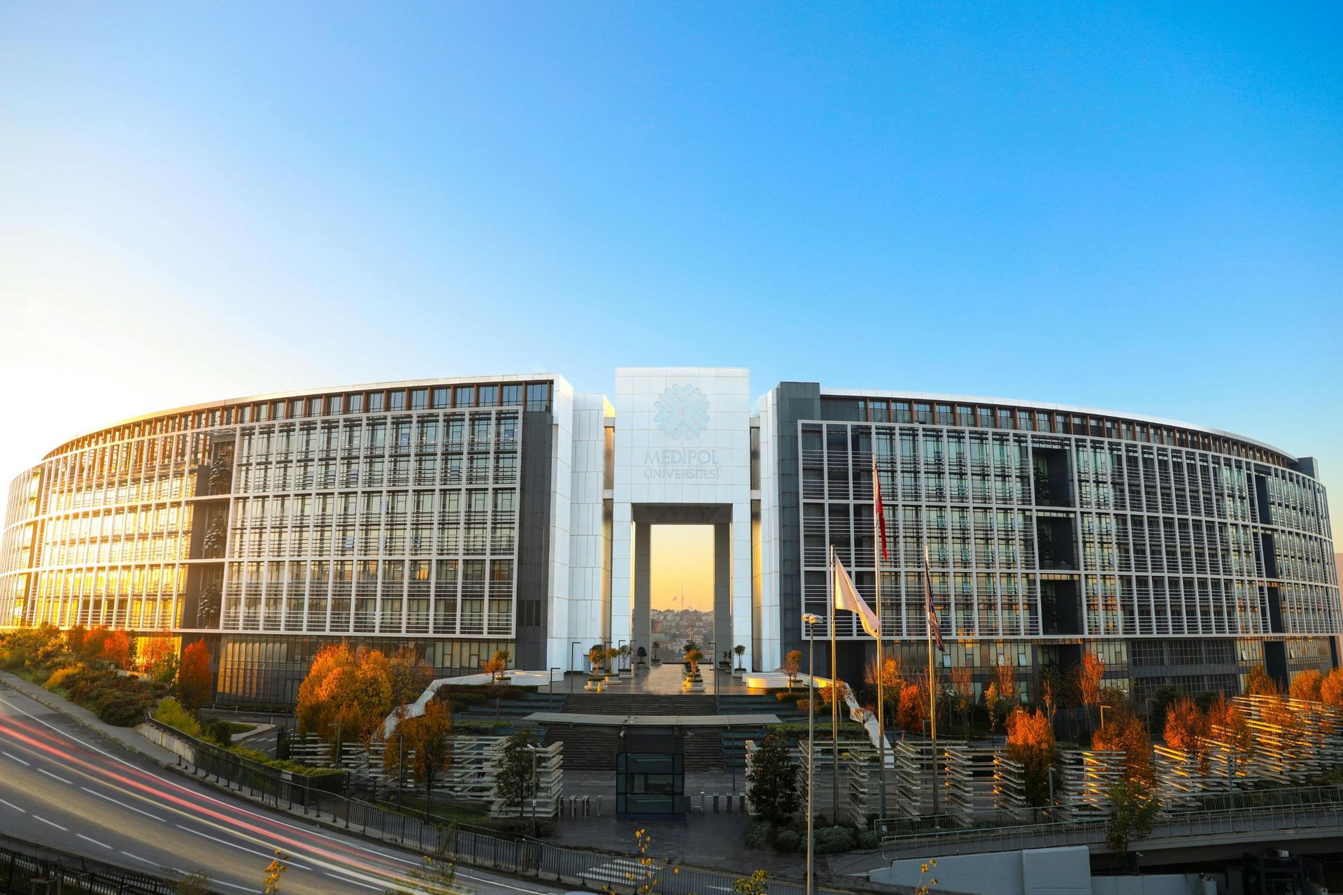 The image features the modern, curved architecture of Istanbul Medipol University's Kavacık South Ca