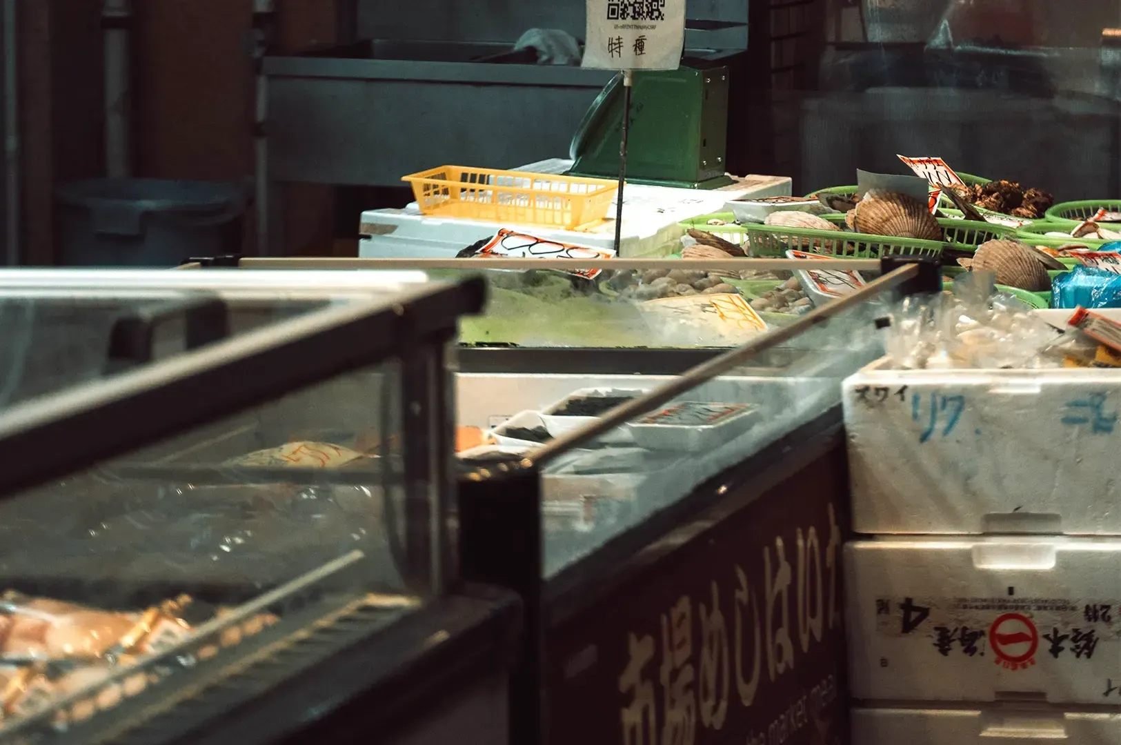 A close-up view of a refrigerated seafood display at a traditional market, showcasing the careful pr