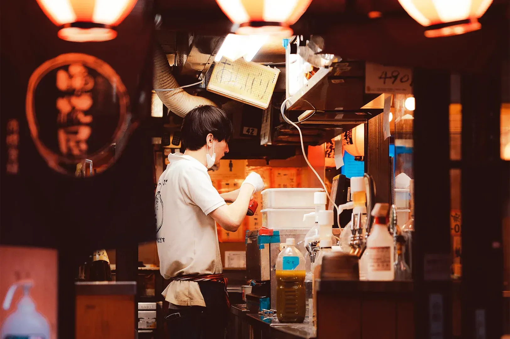 A chef working in a warm, dimly lit restaurant kitchen, symbolizing the quiet dedication and profess