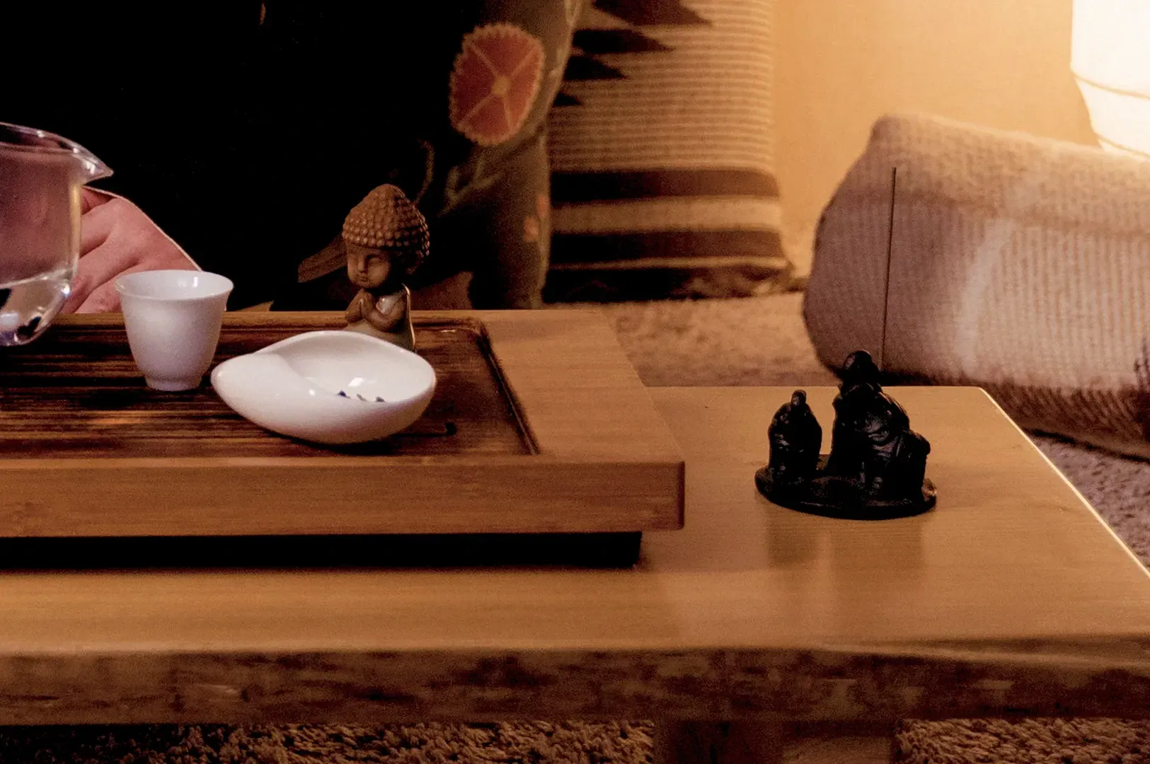 A tranquil tea ceremony setting featuring dim, warm lighting that emphasizes the beauty of restraint and atmospheric shadows, inspired by themes in In Praise of Shadows.