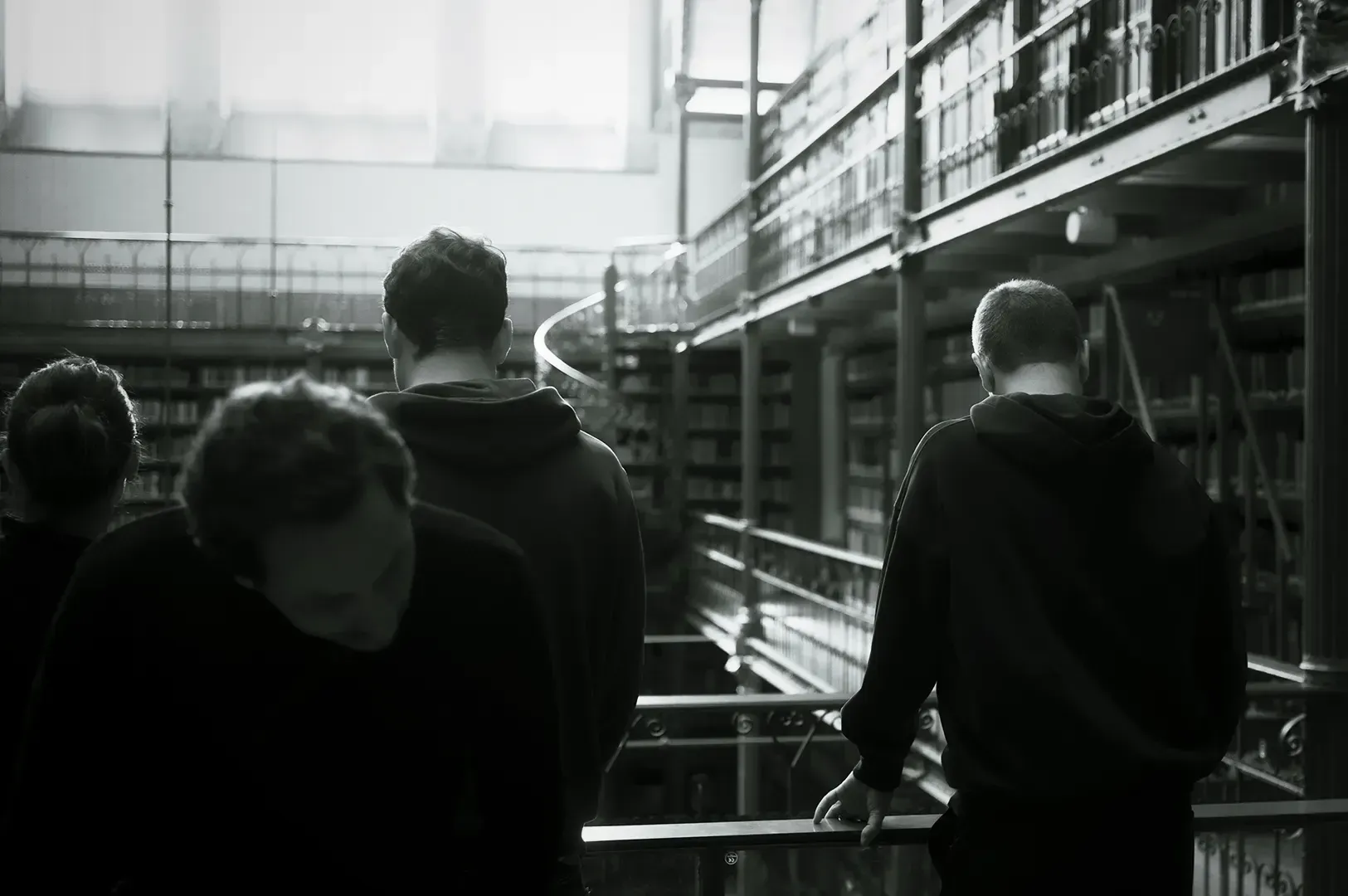 A group of people in a multi-story library, capturing the contemplative and labyrinthine atmosphere reminiscent of the surreal settings in Italo Calvino's Invisible Cities.