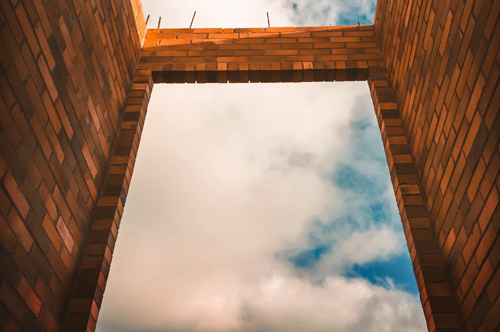 An architectural view looking through an unfinished brick doorway toward the sky, symbolizing the open-ended nature of choosing when everything feels significant.