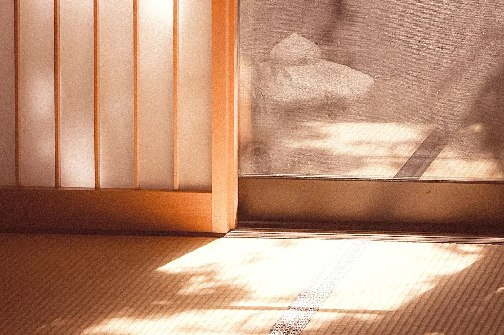 Interior view of a traditional Japanese room with sliding shoji doors, where soft, diffused light and subtle shadows create the depth and patina central to Tanizaki's aesthetic philosophy.