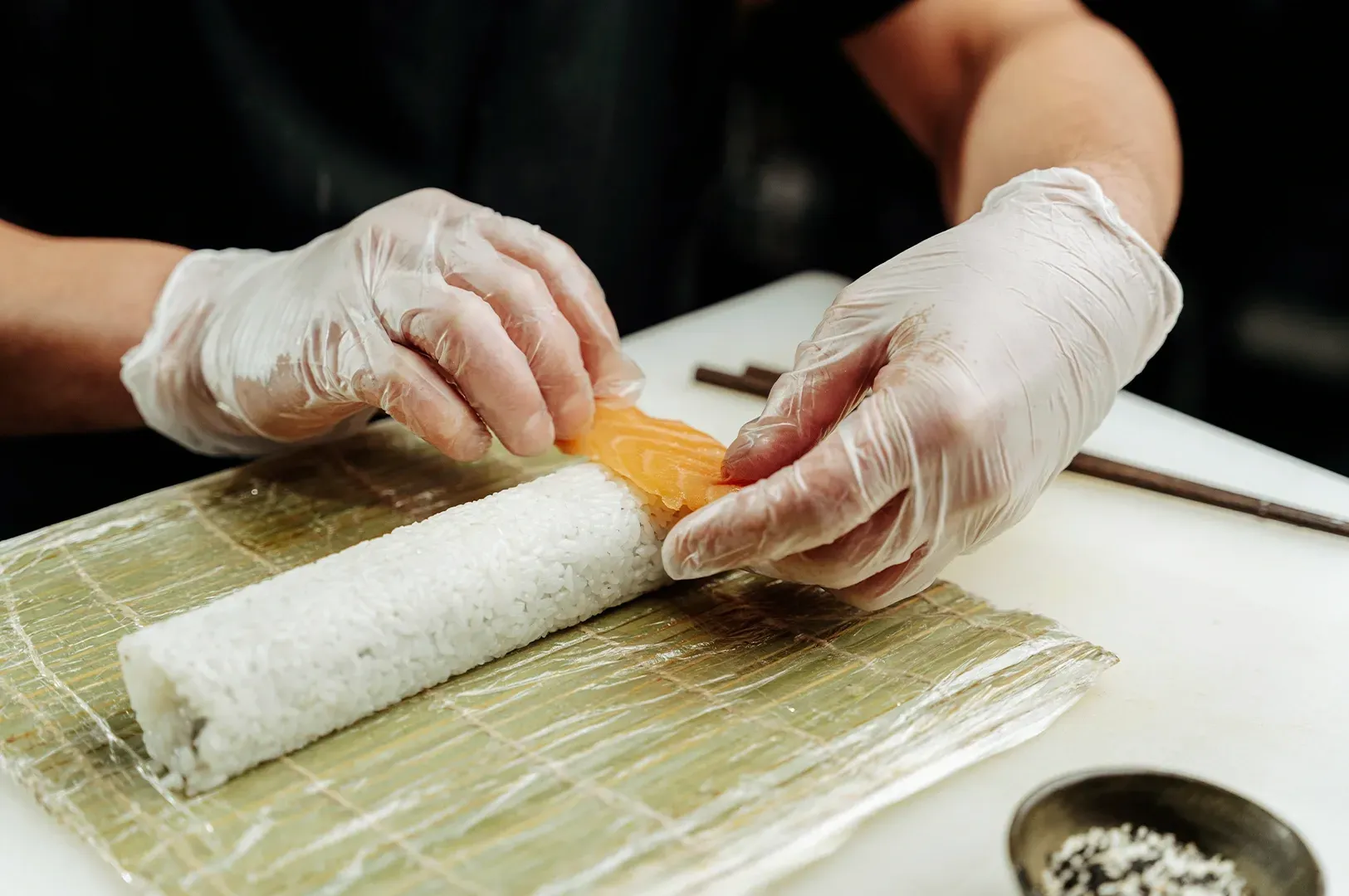 A chef carefully assembling sushi with precision and focus, serving as a metaphor for the slow, disciplined work and high standards needed to build something worth keeping in the early stages of a founder's career.
