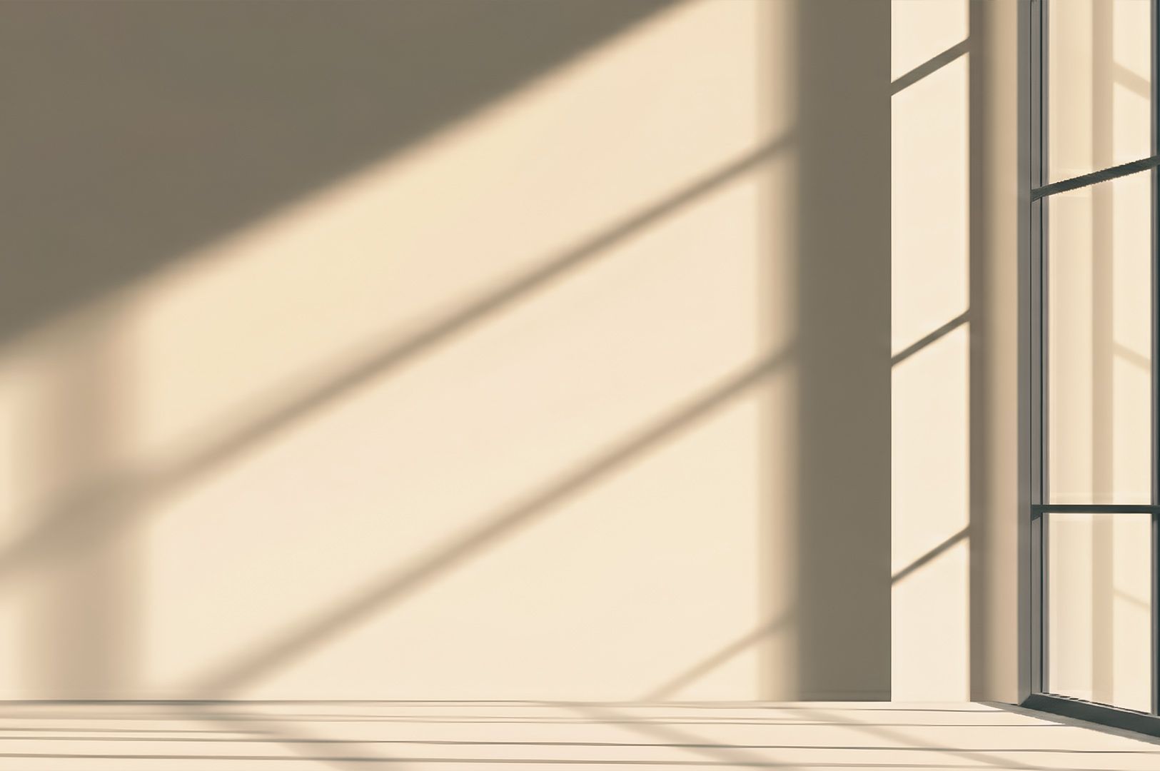 Sunlight streaming through large windows, casting geometric shadows on a minimalist interior wall.