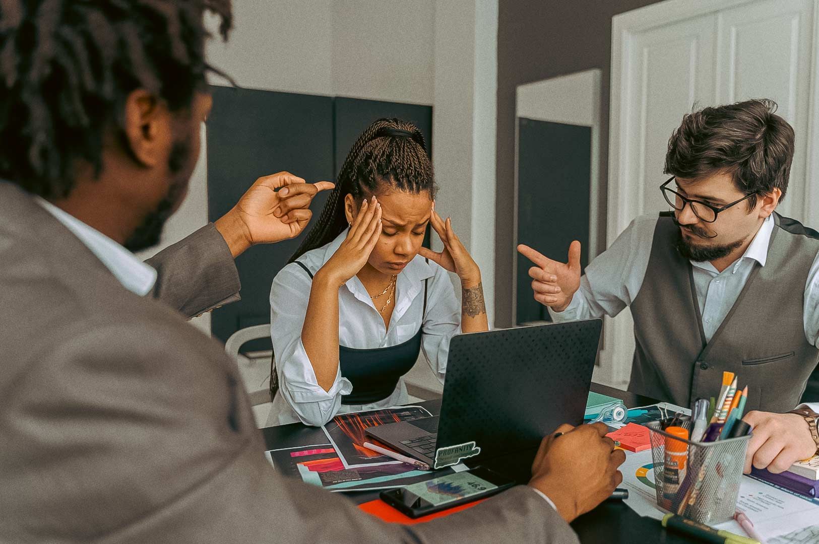 Team meeting at a desk with documents and a laptop in a modern office setting.