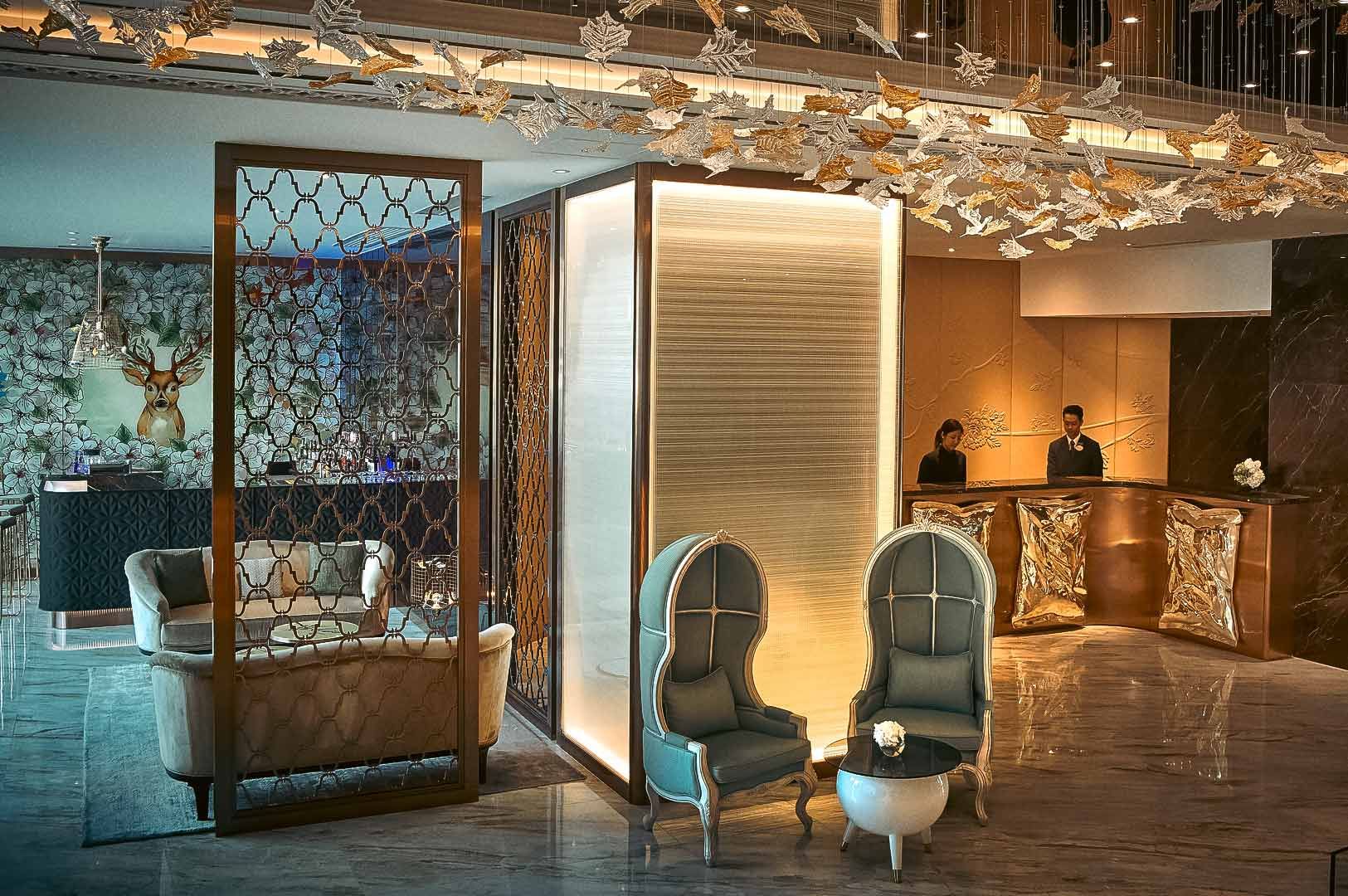 Luxurious hotel lobby with elegant seating, golden accents, and decorative lighting.