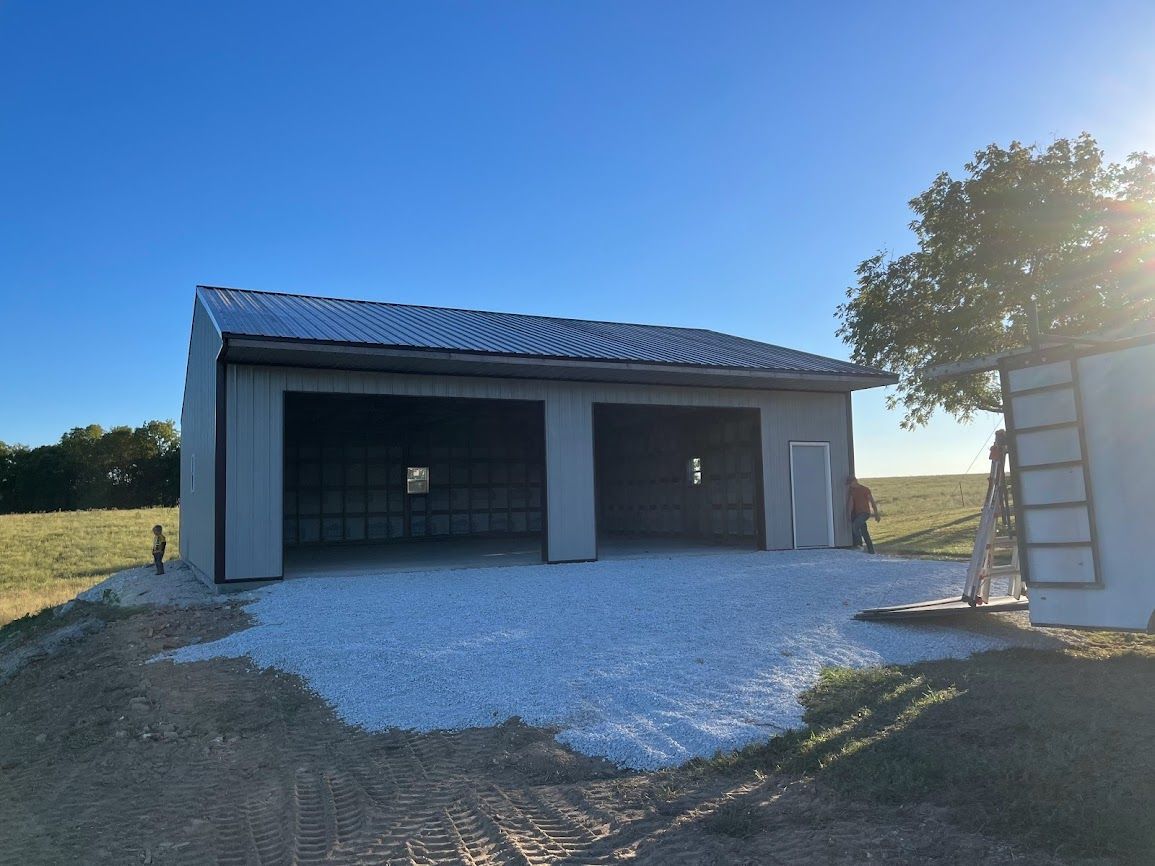 A garage is being built in the middle of a field.