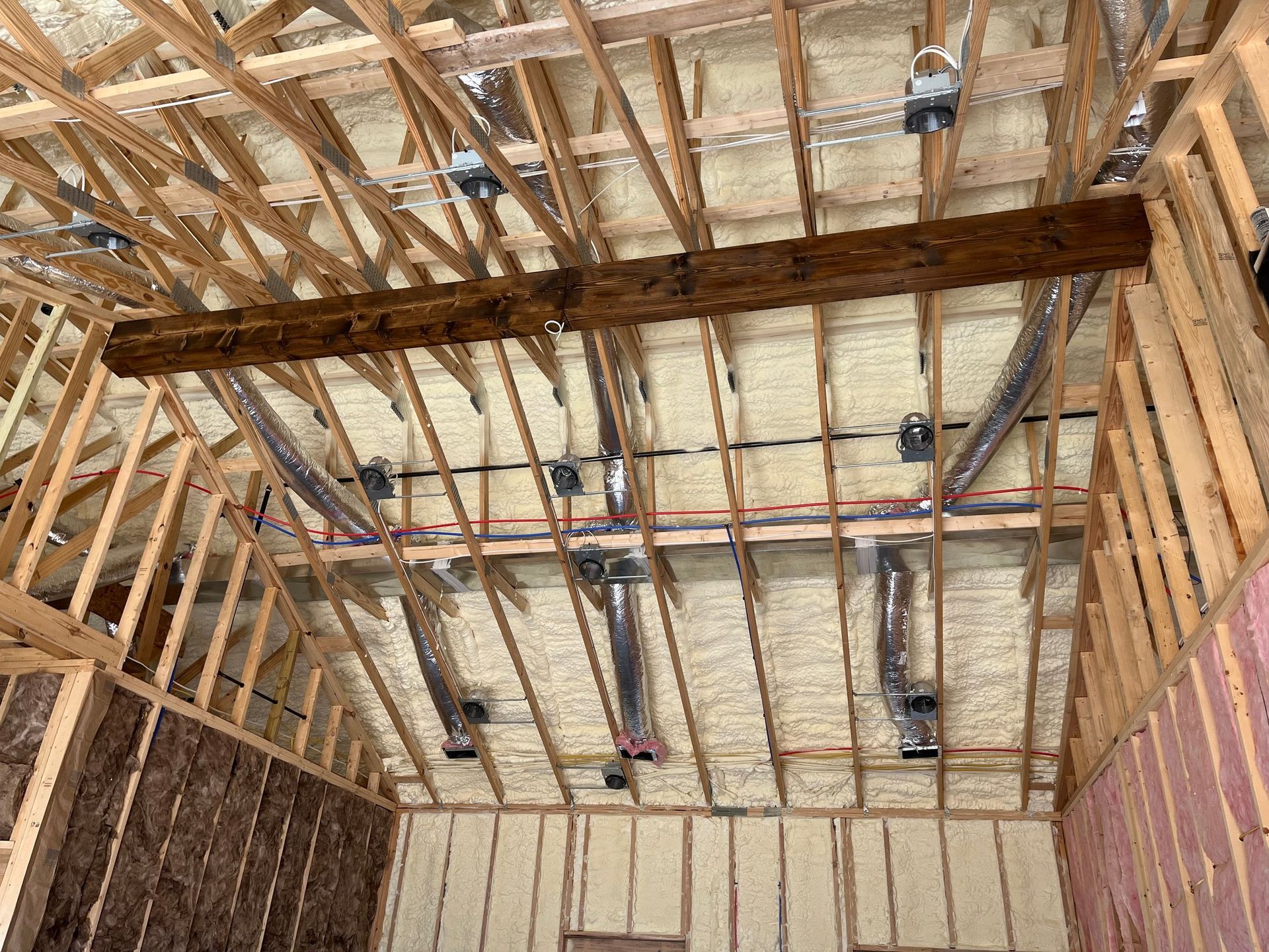 The ceiling of a building is being insulated with spray foam.