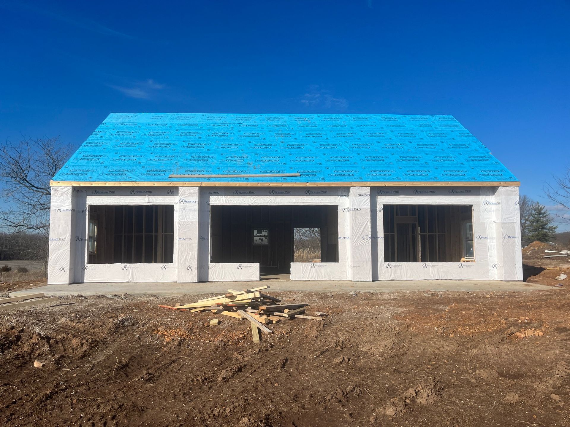A house is being built with a blue roof.