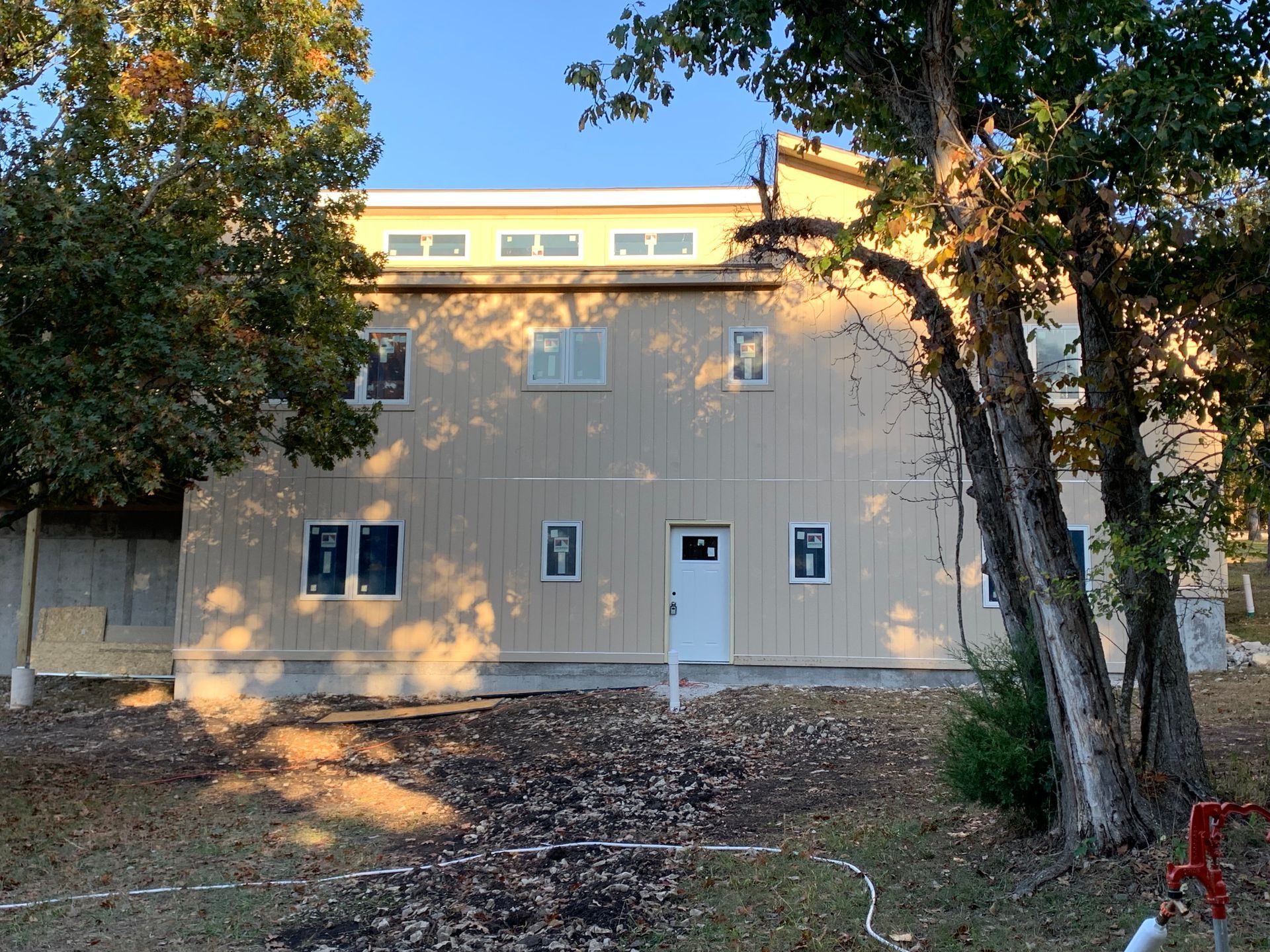 A large building with a lot of windows is surrounded by trees.