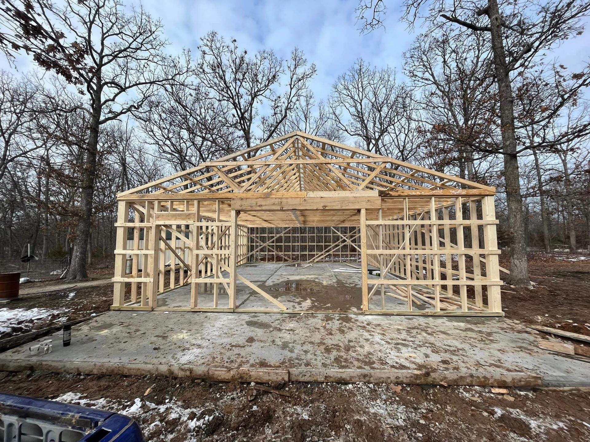 A wooden structure is being built in the middle of a forest.