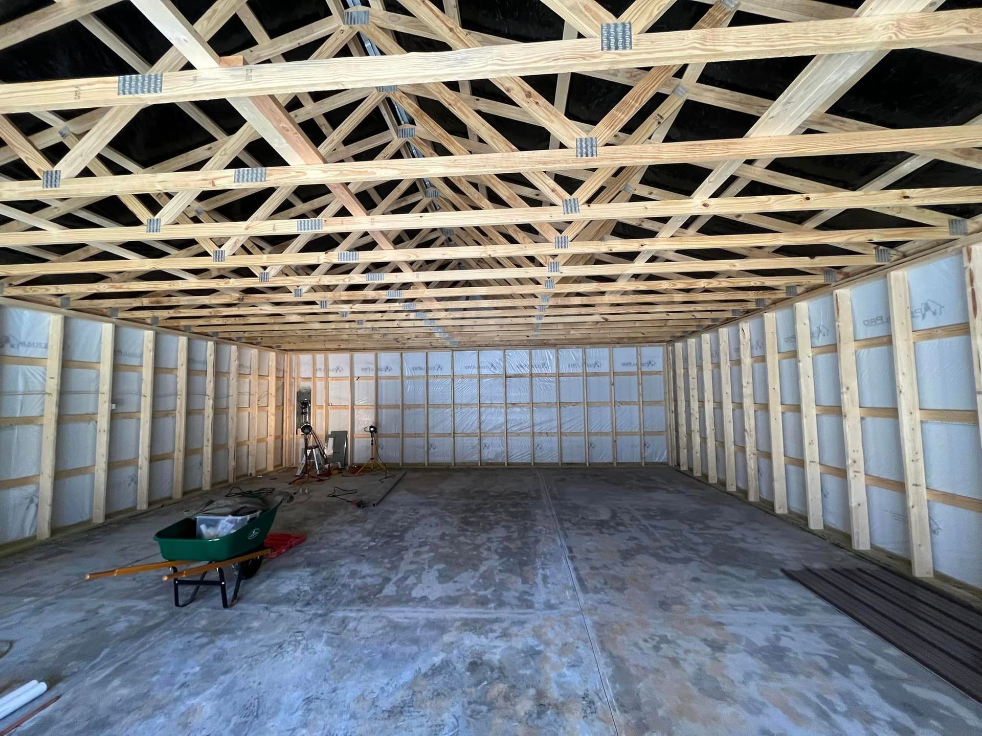 The inside of a building under construction with a wheelbarrow in the middle.