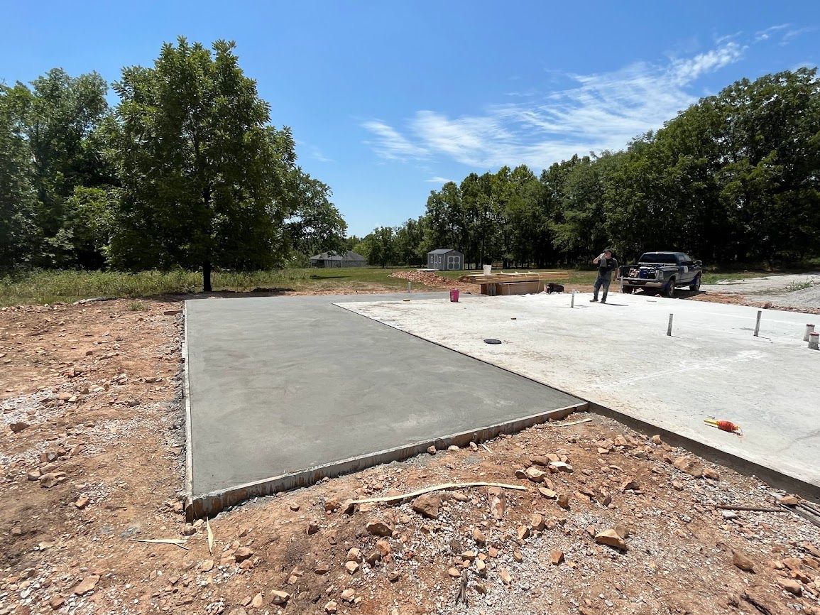 A concrete driveway is being built in a dirt field.
