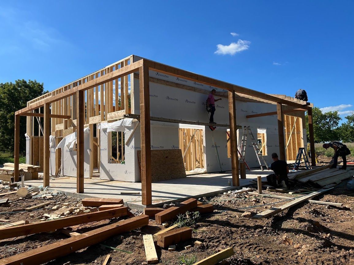 A group of people are working on a house under construction.