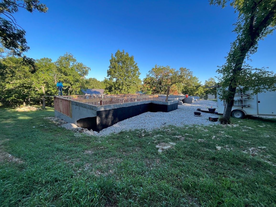 A large concrete structure is sitting in the middle of a grassy field.