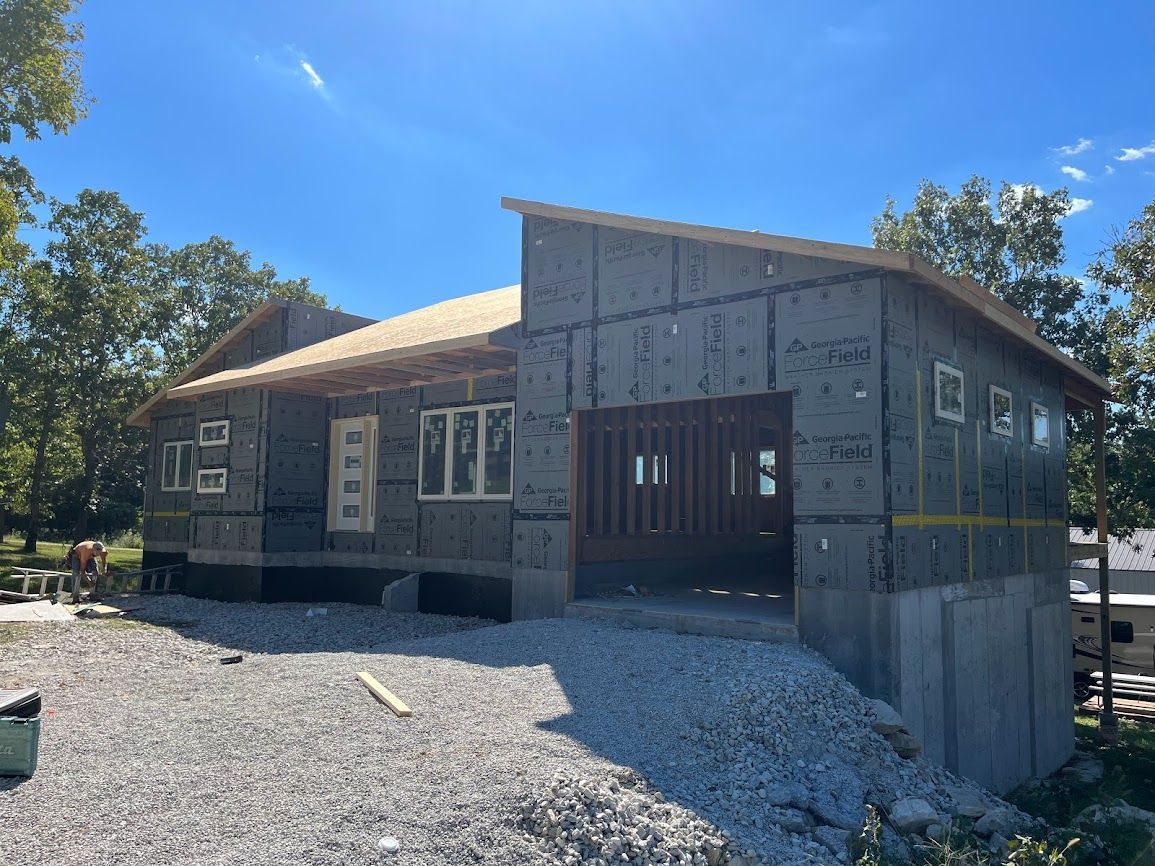 A house is being built on a gravel lot.