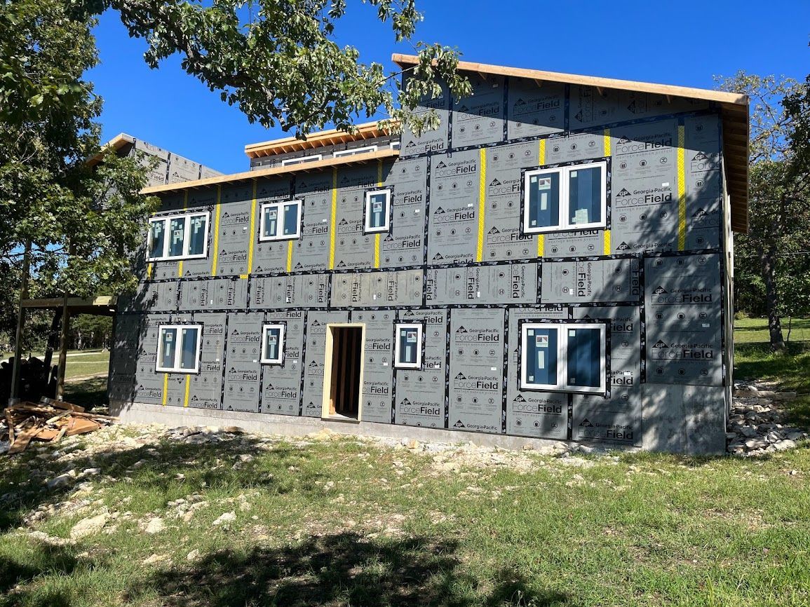 A house is being built in the middle of a grassy field.
