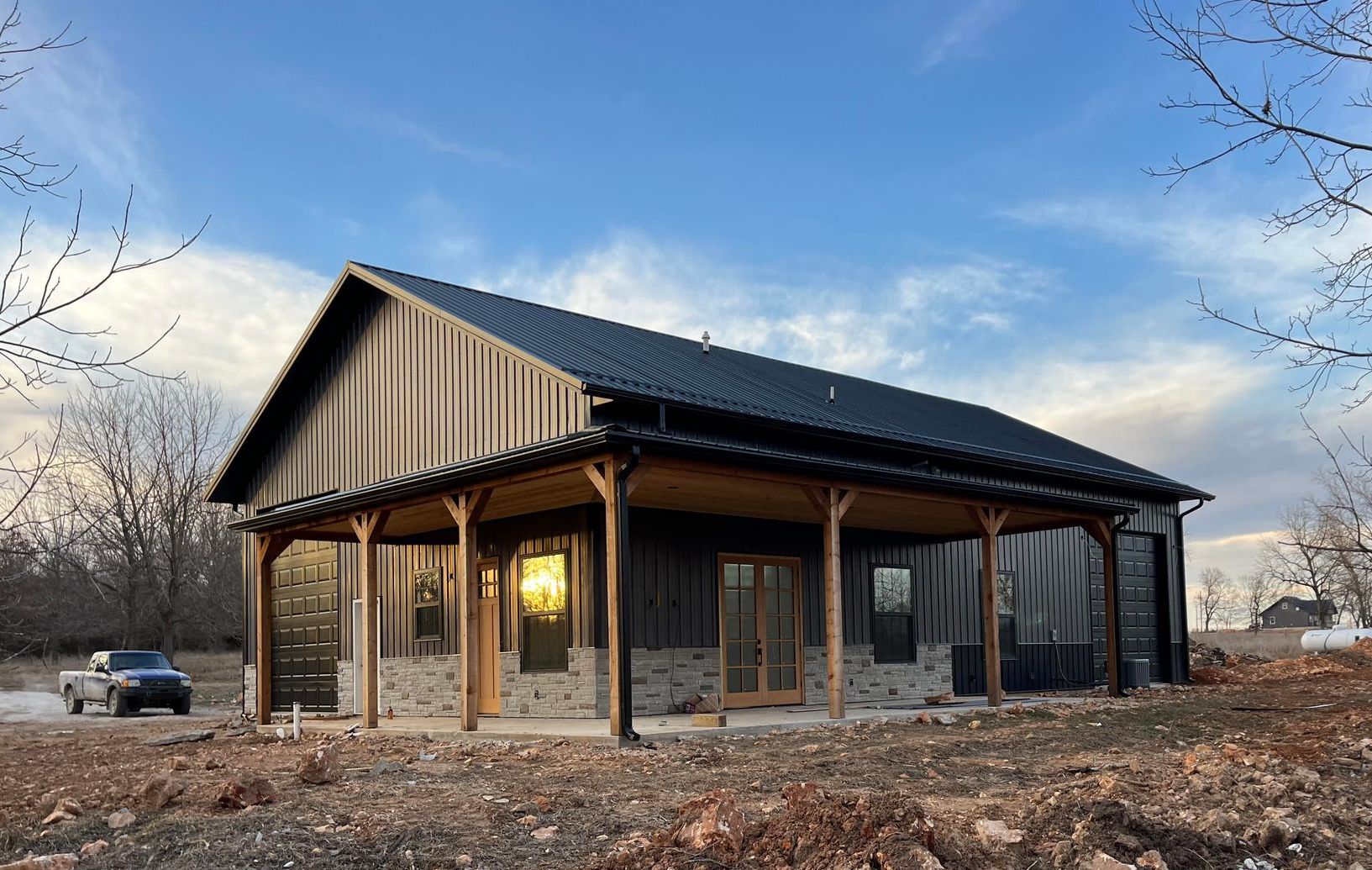 A large house with a porch and a car parked in front of it.