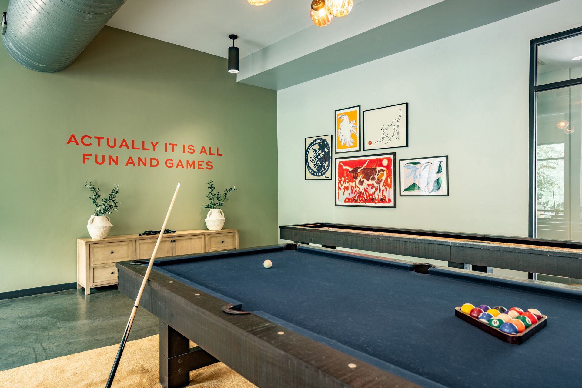 A patio with tables and chairs and a neon sign that says bang