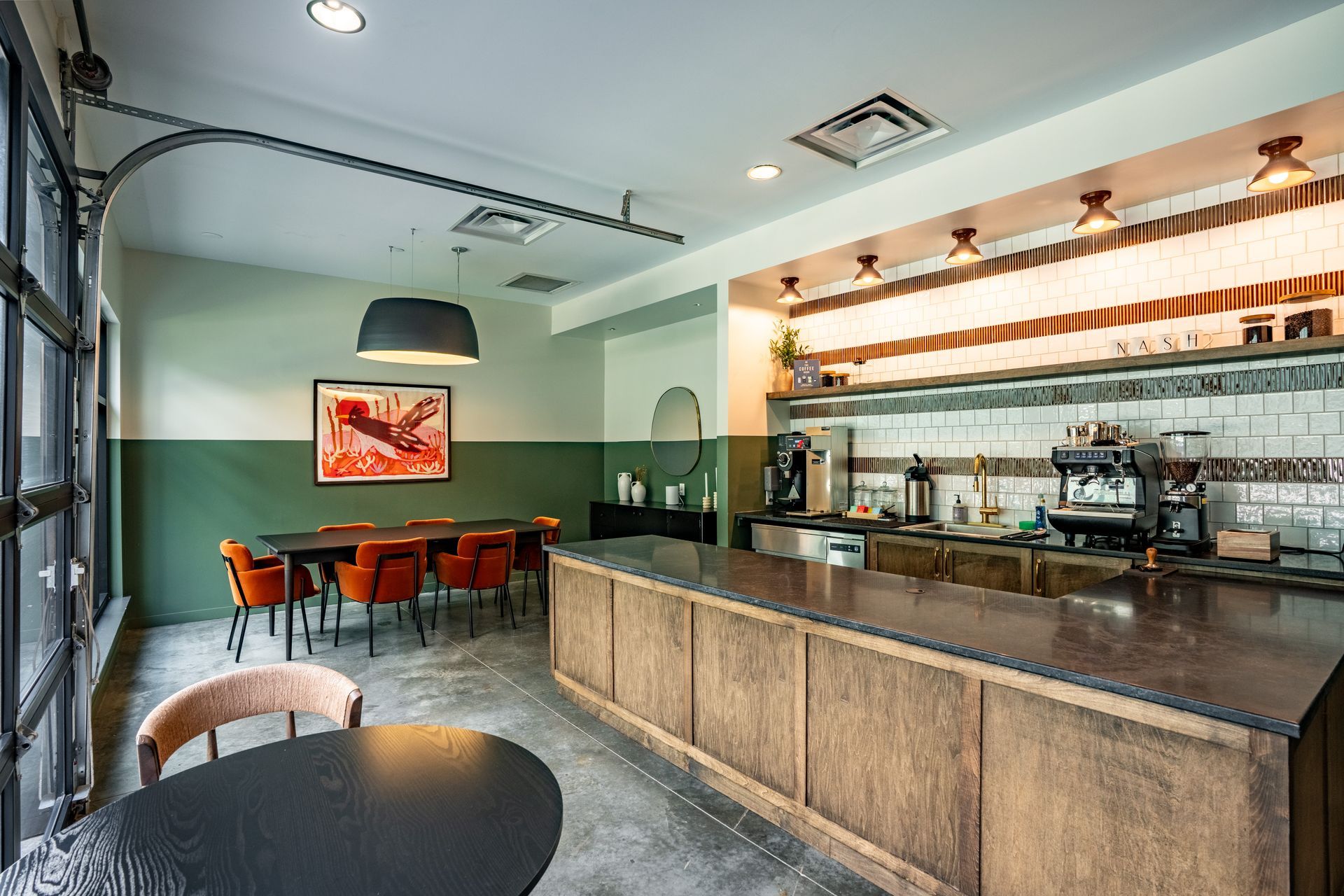 A coffee shop interior with a bar, tables, chairs, and a serving counter. 