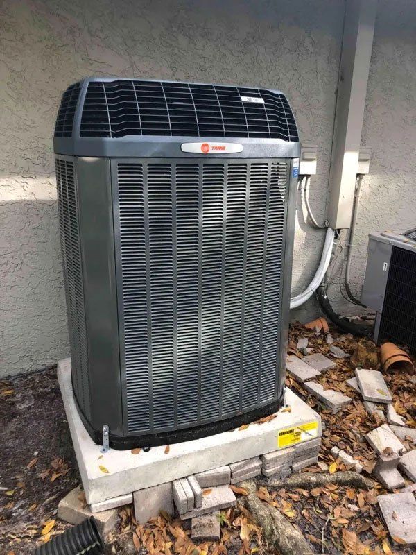 A large air conditioner is sitting on top of a concrete platform.