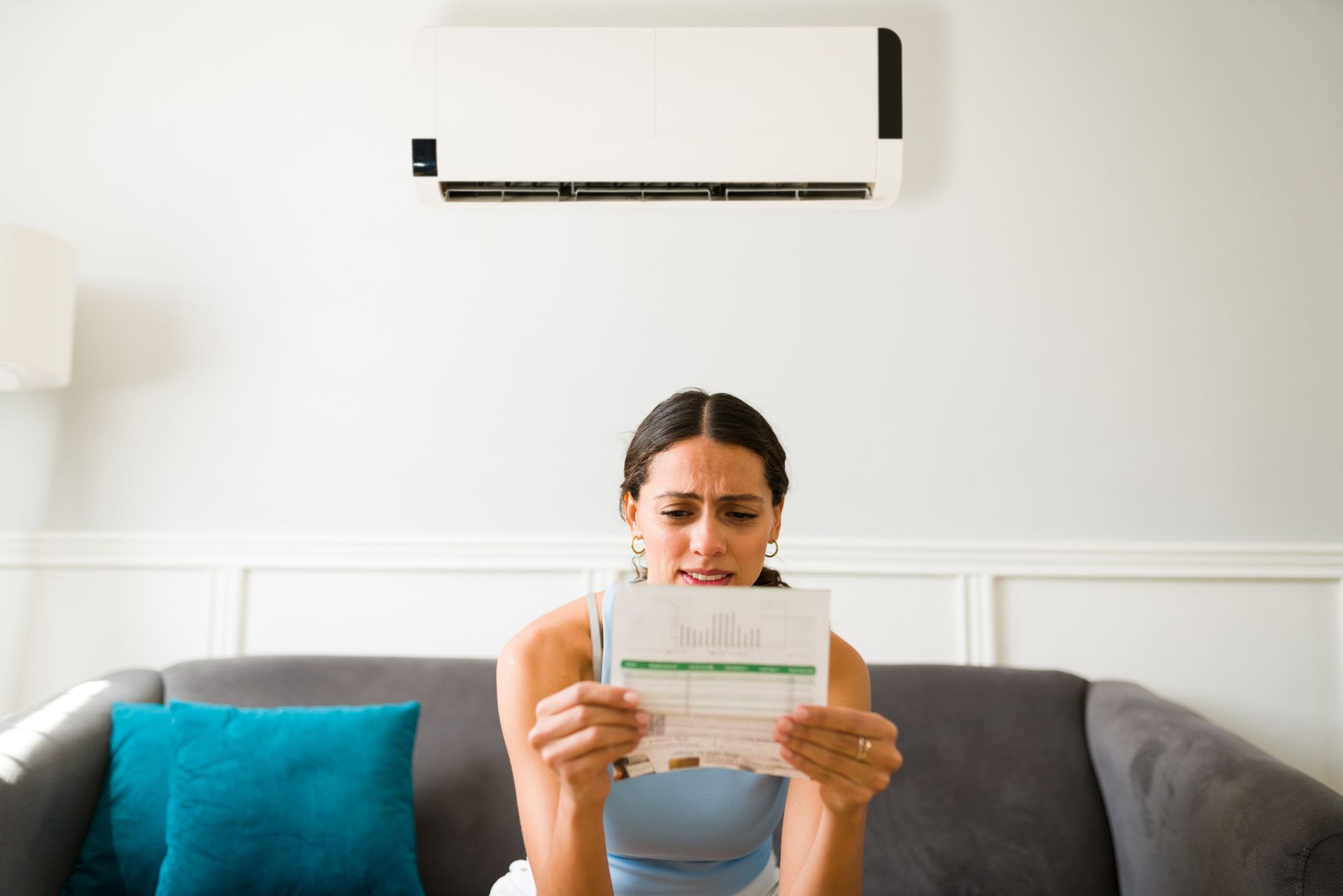 Concerned homeowner checking monthly electricity bill due to high cooling costs. Concerned homeowner checking monthly electricity bill due to high cooling costs.