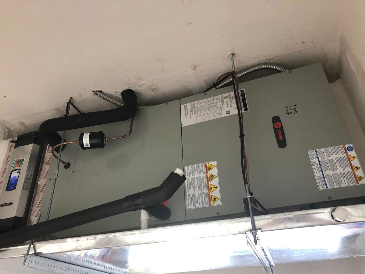 A picture of an air conditioner hanging from the ceiling in a room.