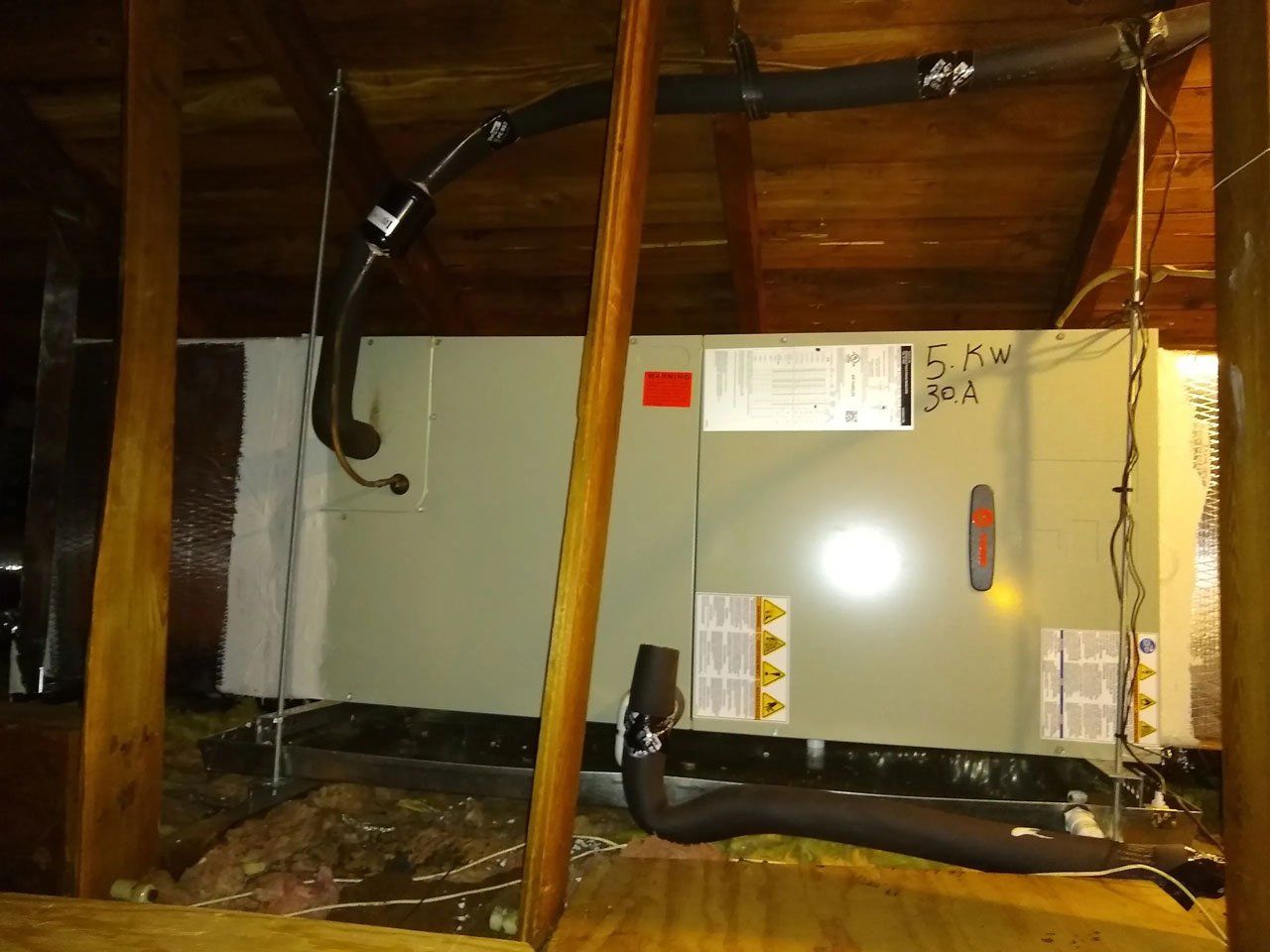 An air conditioner is installed in the attic of a house