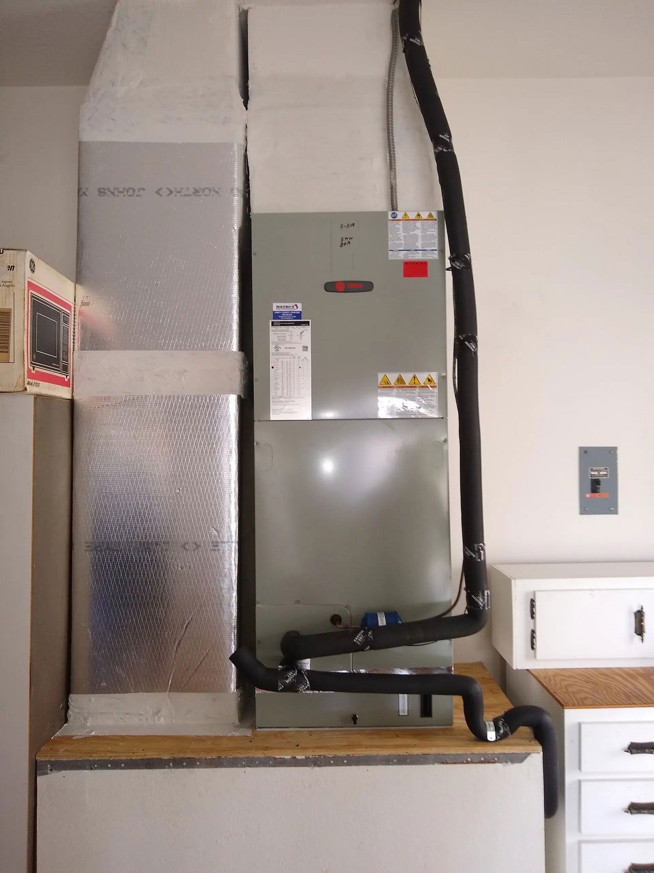 An air conditioner is mounted to the wall in a room