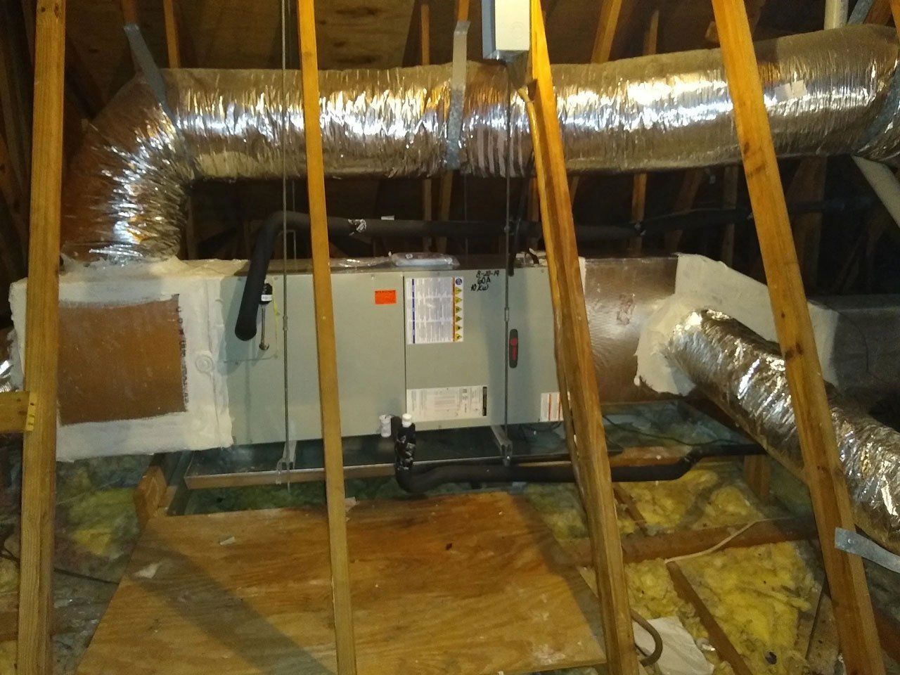 An air conditioner is installed in the attic of a house