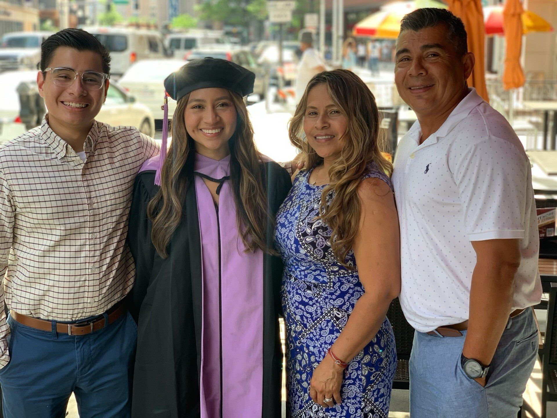 A group of people posing for a picture with a girl in a graduation cap and gown.
