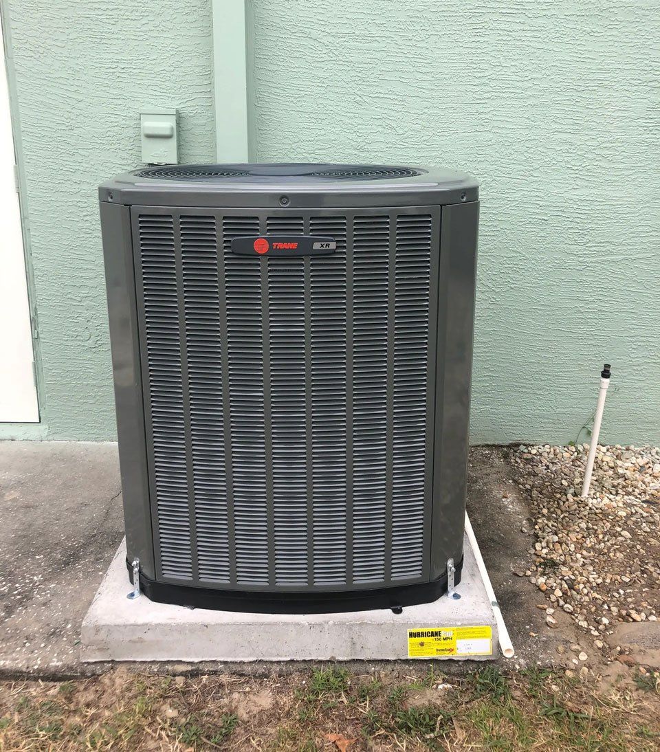 A large air conditioner is sitting on the side of a building.