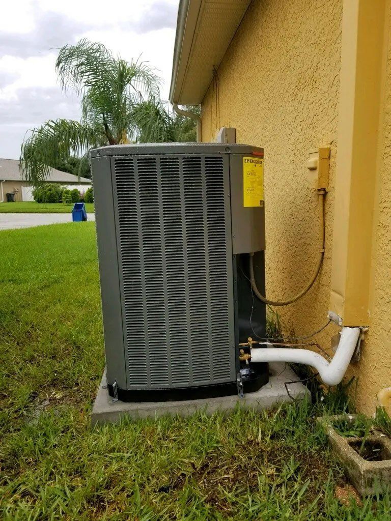 A large air conditioner is sitting on the side of a house.